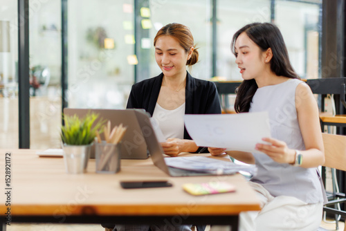 Wallpaper Mural Two managers discussing contract in meeting room or modern office workplace.Two young pretty asia business woman work. Torontodigital.ca