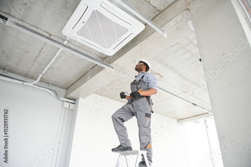 Wallpaper Mural low angle view of african american handyman repairing air conditioner Torontodigital.ca