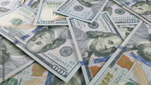 A collection of scattered U.S. Dollar Bills arranged across a flat surface area