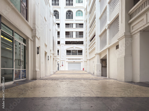 Empty alleyway in a commercial building with white walls and glass doors