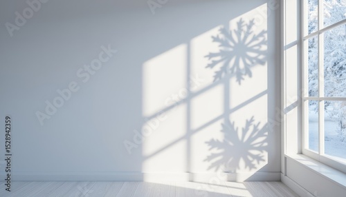 Natural winter light casting snowflake shadows on white wall  
