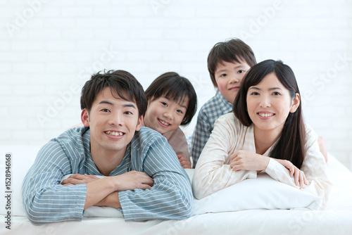 ベッドに寝転ぶパジャマ姿の家族