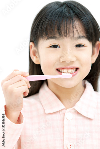 歯磨きをするパジャマ姿の女の子
