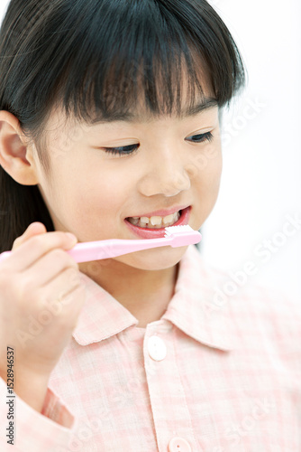 歯磨きをするパジャマ姿の女の子
