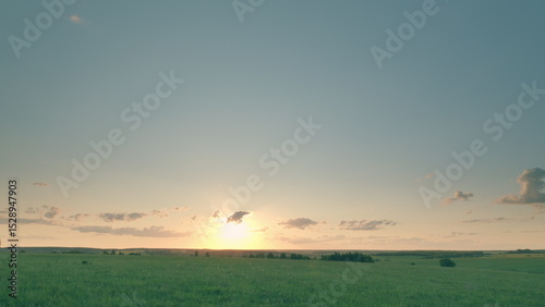 A Serene and Peaceful Sunset Casting Its Glow Over a Vast Green Landscape of Tranquility