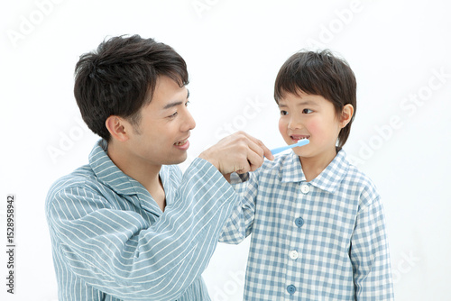 歯磨きをするパジャマ姿の親子