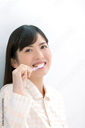 歯磨きをするパジャマ姿の女性