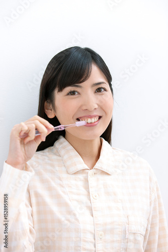 歯磨きをするパジャマ姿の女性