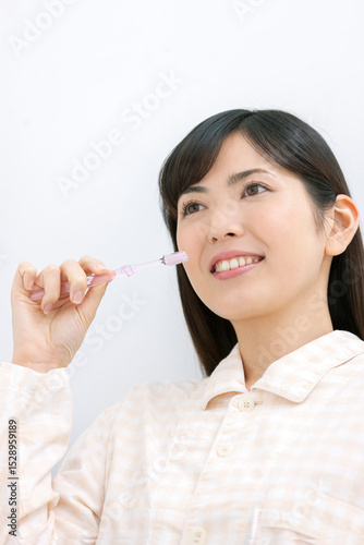 歯磨きをするパジャマ姿の女性