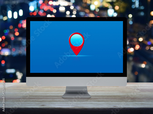 Map pin point location button on desktop modern computer monitor screen on wooden table over blur colorful night light traffic jam road in city, Technology map pointer navigation online concept