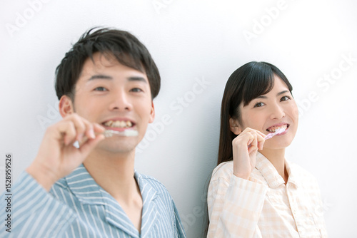 歯磨きをするパジャマ姿の夫婦