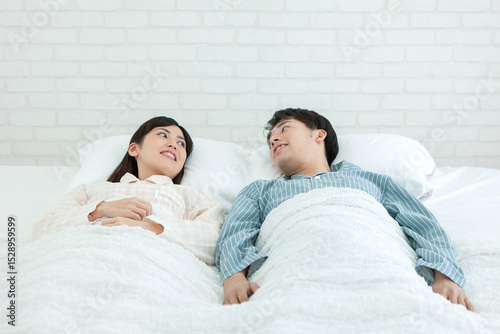 ベッドで話すパジャマ姿の夫婦