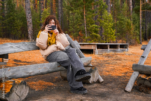 Autumn. A woman sits on a rustic bench surrounded by vibrant autumn foliage, capturing the beauty of nature