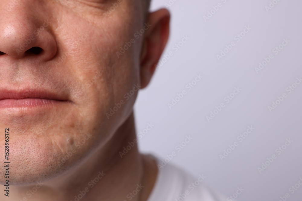 Obraz premium Clean shaven man on light background, closeup. Space for text