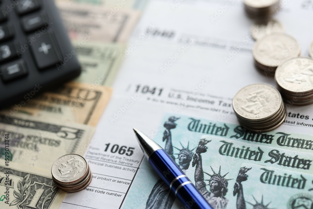 American US dollars money bills and coins with pen and calculator on IRS tax form blanks American US dollars money bills and coins with pen and calculator on IRS tax form blanks