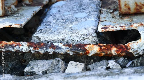 A large crack on an old wall and rusty iron.