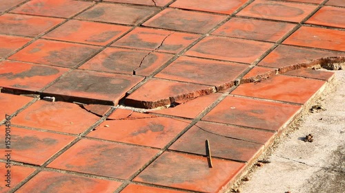 A large crack on an old tile floor.