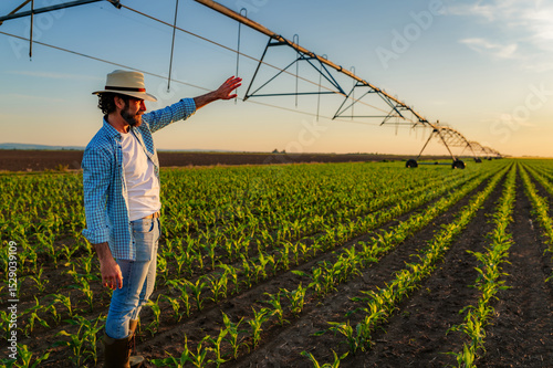 Papier peint Farmer gestures towards his cornfield, proudly surveying his crops under a cente