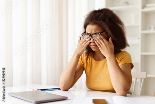 Φωτογραφία Exhausted black woman rubbing tired eyes, suffering from eyestrain after using l
