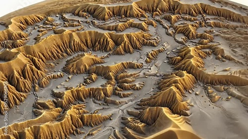 Detailed aerial view of rugged terrain showcasing golden mountains and valleys.