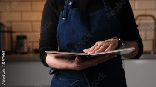 Woman Checking Recipe Book In The Kitchen