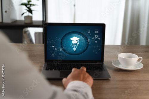 E-learning Platforms person sitting wooden table front of laptop displaying digital education or learning icon with graduation cap and light bulb