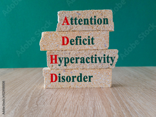 Attention deficit hyperactivity disorder ADHD concept. Neurodevelopmental disorder characterized by inattention, impulsivity and hyperactivity. Inscription on brick blocks on green background.