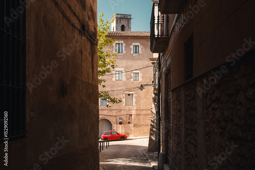 Spanische Altstadt Sonnenlicht und Schatten Rotes Auto in der Altstadt in Enger Gasse Girona photo