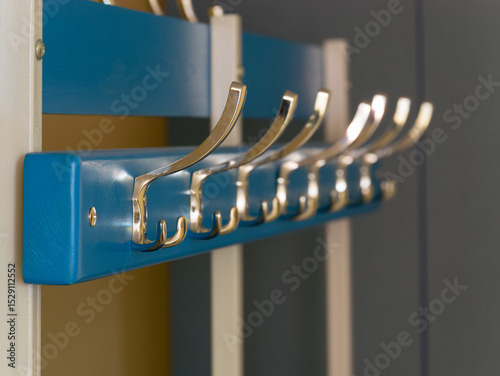 Selective focus on coat hooks screwed on wooden clothes hanger in locker room photo