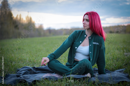 A beautiful girl walks on a green field. Posing in nature. 