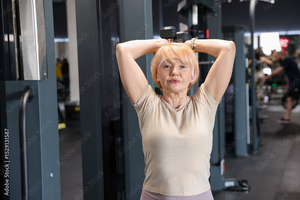 Senior woman training with dumbbells in gym Senior woman training with dumbbells in gym