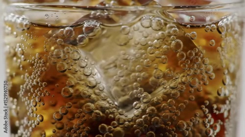 Close-up fizzy soda with ice, photorealistic animation of bubbles and condensation