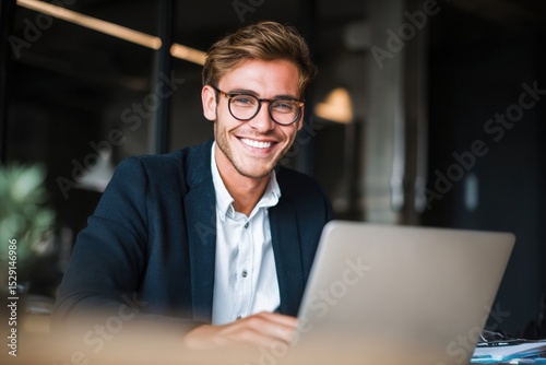Wallpaper Mural Young smiling businessman working on a laptop in the office. Torontodigital.ca