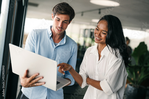 Two happy diverse multiethnic business team people working, talking in corporate office
