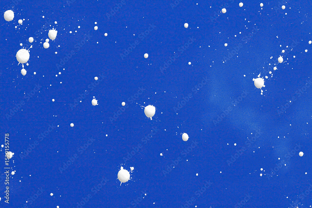 Fototapeta premium Small white droplets scatter across vibrant ultramarine field in chaotic arrangement.