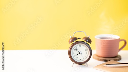 classic alarm clock and a cup of coffee on stacked books illustrating time management, work and education focus
