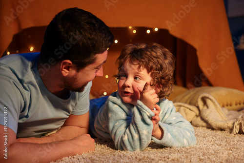 Tableau sur toile Father and his son before bedtime on floor at home
