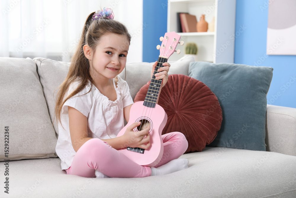 Cute girl playing toy guitar on sofa at home Cute girl playing toy guitar on sofa at home