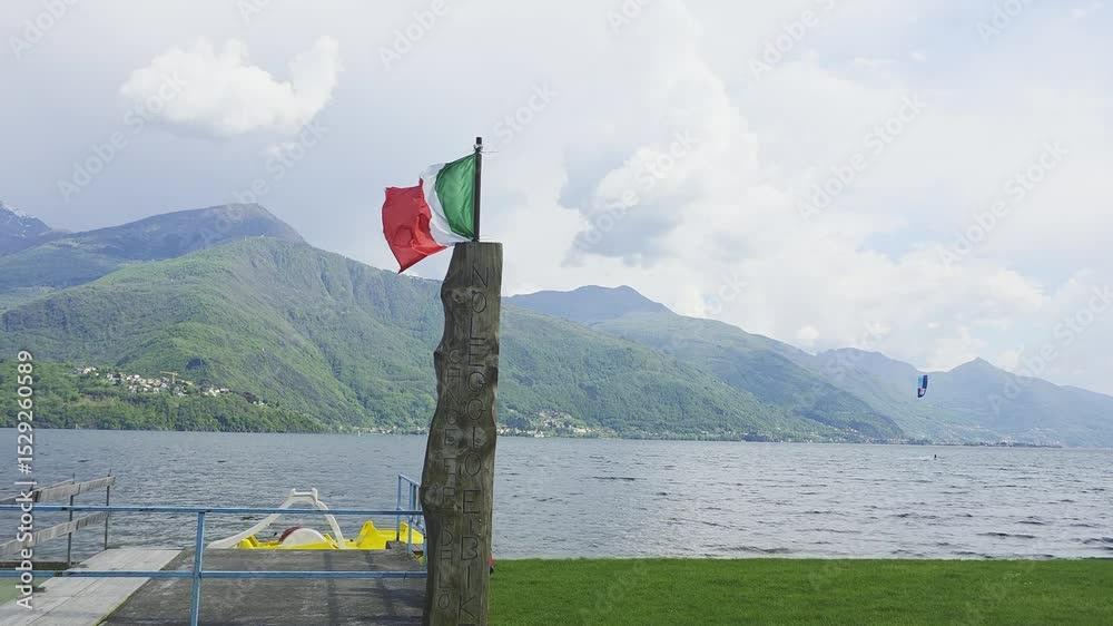 A flag in the fore ground wiht a windsurfer in the bacground on wonderfull Lake Como in Italy.