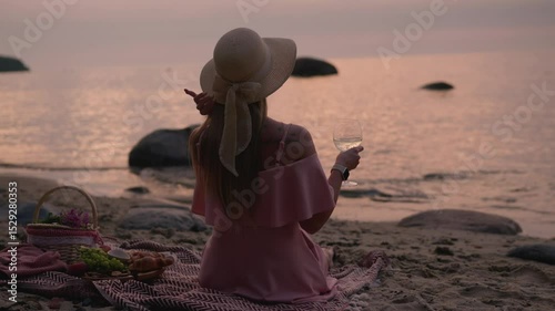 Young woman in straw hat sit on plaid have picnic on sea sunrise sand beach 