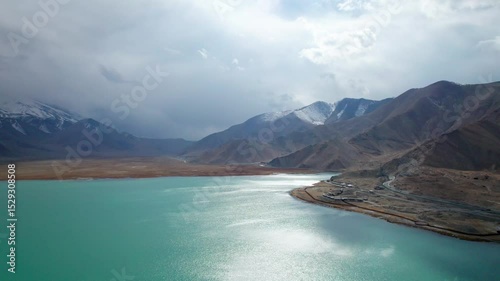 Drone view of Karakul Lake‌ on sunny cloudy day in Tashkurgan County, Kashgar, Southern Xinjiang, China. Aerial landscape of landmark on Pamir plateau, 4k real time footage, travel concept.