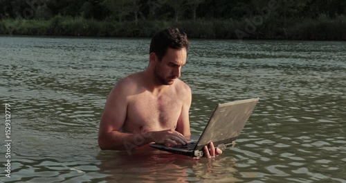 Using work laptop on the beach in the water