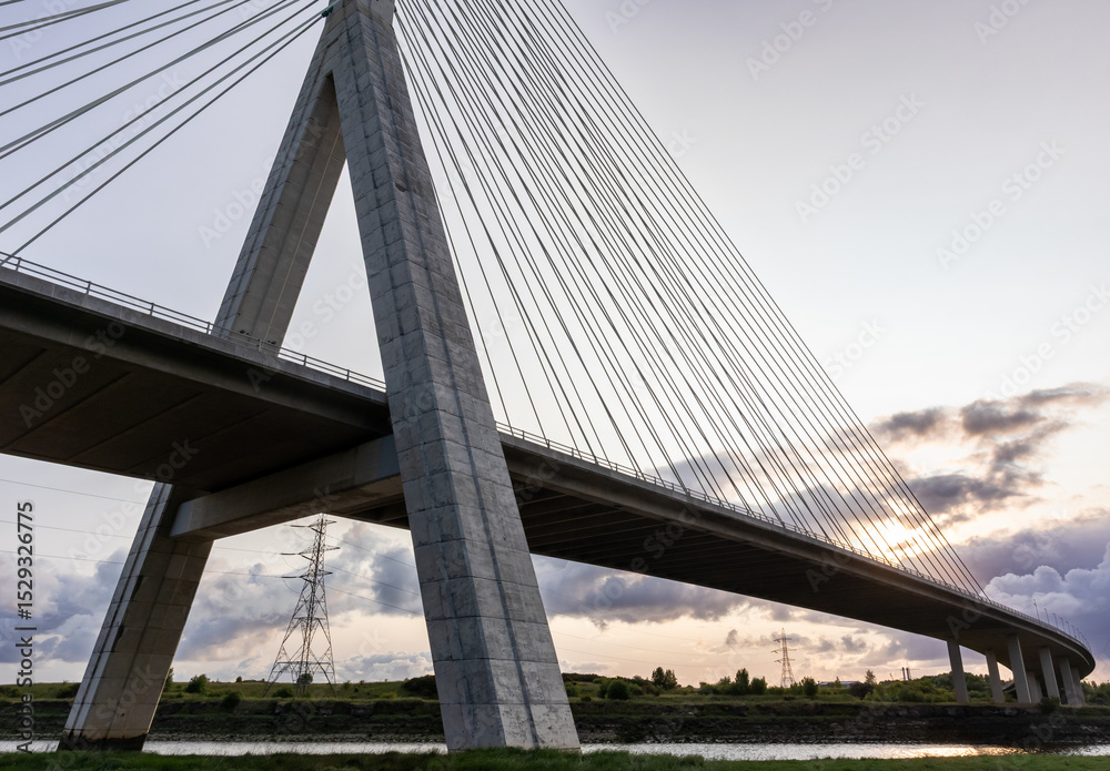 Obraz premium Flintshire Bridge stands prominently in the soft light of early morning, with its cables and concrete structure leading into the distance