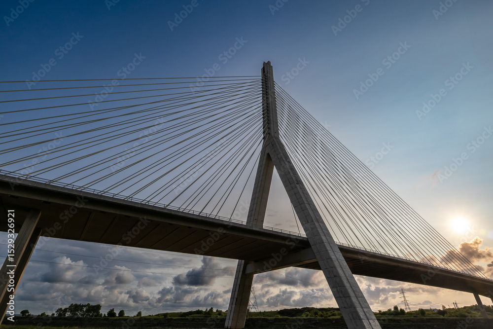 Fototapeta premium Flintshire Bridge stands prominently in the soft light of early morning, with its cables and concrete structure leading into the distance