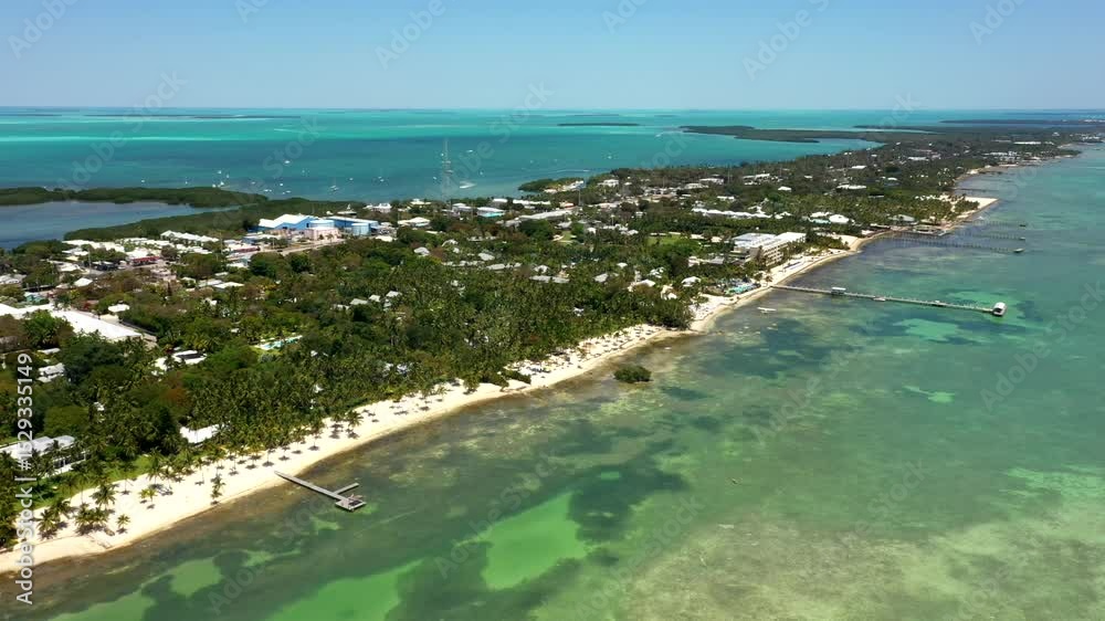 Aerial establishing of Lodge coastline with bright turquoise water and resort area, midday Aerial establishing of Lodge coastline with bright turquoise water and resort area, midday