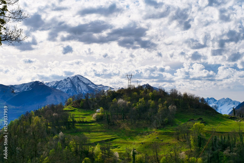 Mountain range with a cloudy sky and a small house in the middle