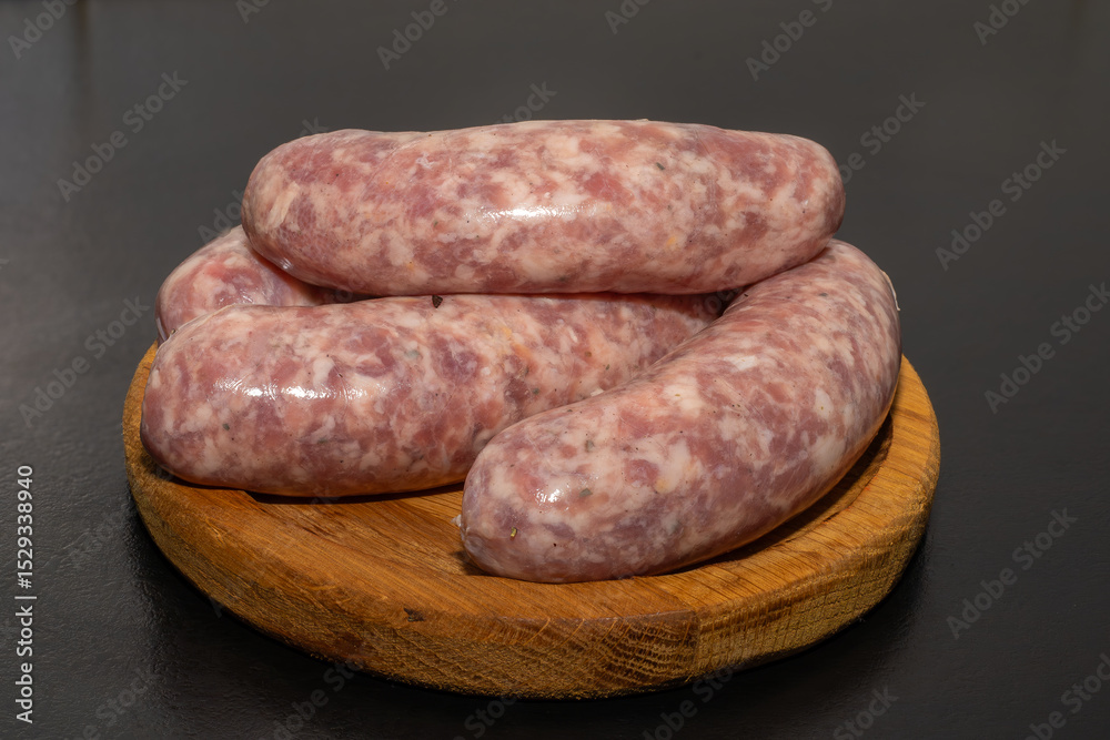 Meat sausages prepared for grill on a wooden board. Raw sausages for grill. Meat sausages prepared for grill on a wooden board. Raw sausages for grill.