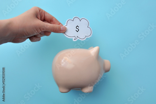 A piggy bank and dollar signs next to it are a symbol of accumulation and saving of finances.
