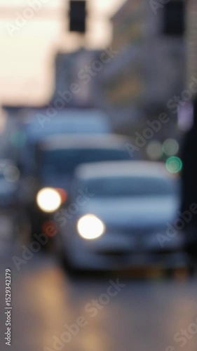 Blurred city street scene with glowing headlights and silhouettes of cyclists