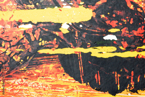 Thick red black and yellow paint in a scribbled abstract background